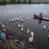 Volunteer Tony Wallin, of Arcata, helped move the lighted lanterns away from the shore into the gentle breeze blowing across Klopp Lake.