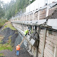 Workers gather data from load sensors on a retaining wall at one of the fail points.