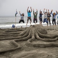 The Northcoast Environmental Center team members took to the air when they finished their "Lend a Hand, or Eight" sand sculpture. It later won the People's Choice award.