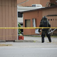 Humboldt County Sheriff's deputy wearing safety gear to examine the package.