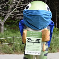 Super Salmon (Zoo mascot) holds one of the new signs to help promote safety around the Zoo.