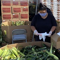 Food for People team member Veronica Brooks packing produce in preparation for a free produce distribution distribution.