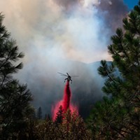 A helicopter drops retardant in an effort to slow the fire’s advance, helping ground crews hold the line.