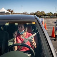 Diane Ahern swabs herself for COVID-19 at a testing site at the Long Beach Airport in Long Beach on Jan. 11, 2022. “I need to get tested every three days to be able to visit my parents at their retirement home,” Ahern said. “I’m nervous.” Photo by Pablo Unzueta for CalMatters