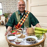 Ben Khounsinavong returns a katoke filled with offerings to the kitchen during the Lao New Year celebration.