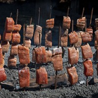 Salmon cooking on stakes for the annual luncheon.