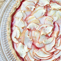 Baked crostata di mele with delicate sliced apples and a golden shell.