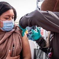 Florinda Matias Pablo receives a COVID-19 vaccination at the La Clinica de la Raza community vaccination site in Oakland on Jan. 4, 2022.