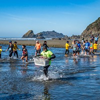 Trinidad to Clam Beach runners crossing Little River as a volunteer shuttles shoes.