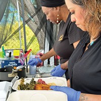 Serving up greens and plantains in the Mother's Cooking Experience stall at the 2023 Juneteenth celebration at Halvorsen Park.