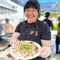 Maya Matsumoto serving okonomiyaki at Obento's 2023 Oyster Fest booth.
