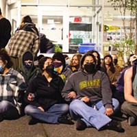 Protesters sit in front of Siemens Hall on April 22.