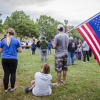 Mike Grimaldo, of Fortuna, held a flag with a blue stripe at the candlelight vigil in Fortuna on Friday evening. "The Thin Blue Line" is a symbol used to commemorate fallen law enforcement officers.