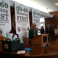 Supervisor Virginia Bass speaks at the launch of the city and county's Housing First campaign. The cleaning supplies were donated by a local outreach group as a "welcome home" gift to new renters.