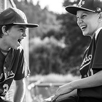 First Place Winner: John Harding, left, and Enzi Stuggard share a laugh with their team at the plate during a May 30 baseball game in Redway. "I was taking action photos and then turned around and snapped this because friendships made, both with the kids playing and their parents, are such a big part of sports," explains photographer Briar Parkinson. "These boys go to different schools but are friends through the sports community."