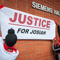 Students hang a "Justice for Josiah" banner on the Humboldt State University quad. At the rally, organizers encouraged those in attendance to scrawl messages of hope, unity and protest on it.