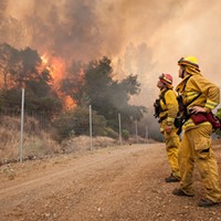 Chris Mitchell, left, and Arly Allen watch the progress of the fire as it slowly burns towards a private road on the Cache Creek Winery in Lake County.
