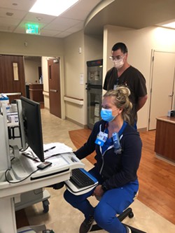 SUBMITTED - Nicole Totten (seated) and Travis Morgan, both registered nurses, discuss COVID-19 patient care at St. Joseph Hospital.