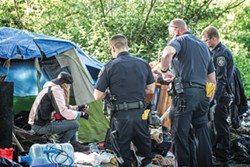 PHOTO BY TED SOQUI FOR CALMATTERS - Eureka police speak to a homeless resident while clearing an encampment.