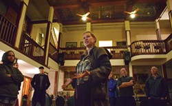 PHOTO BY JENNIFER FUMIKO CAHILL - Alex Service regales the tour group with tales of haunted rooms in the Eagle House Inn.
